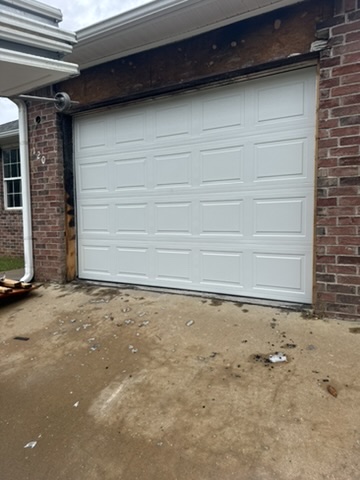 Elite Garage Door Services of Northwest ArkansasA newly installed white residential garage door is shown on a brick house in Rogers AR. The surrounding area is clean, indicating recent garage door installation service by a local professional in Northwest Arkansas.