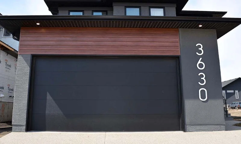 Elite Garage Door Services of Northwest ArkansasA modern residential garage with a black overhead garage door and wooden paneling, located in Northwest Arkansas. The house number 3630 is visible on the side, highlighting local garage door service options in the area.