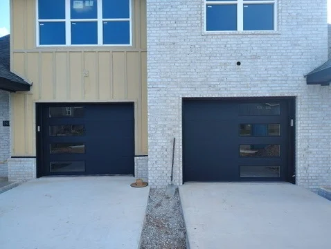 Elite Garage Door Services of Northwest ArkansasTwo modern residential garage doors with black finishes are installed on a brick house in Northwest Arkansas. The clean, professional installation highlights the reliability of…