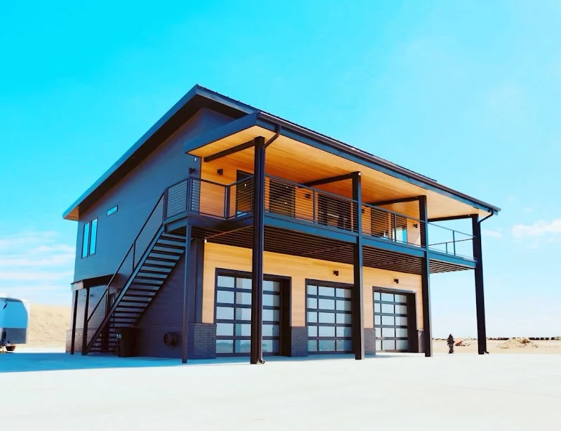 Elite Garage Door Services of Northwest ArkansasA modern building with three large glass residential garage doors under a wooden balcony, set against a clear blue sky, showcasing reliable garage door installation services in Northwest Arkansas.