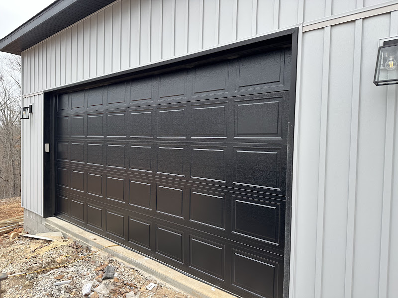 Elite Garage Door Services of Northwest ArkansasA newly installed black residential garage door on a gray building in Northwest Arkansas, showcasing local, reliable garage door service.
