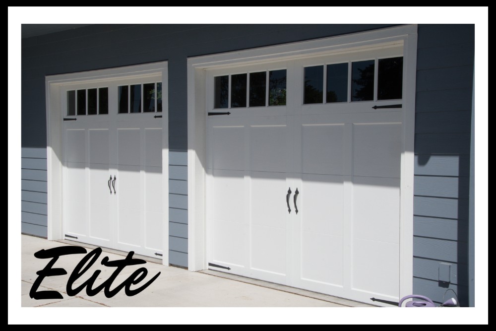 The Complete Guide to Garage Door Springs and How to Care for Them-2 Elite Garage Door Services of Northwest Arkansas-A pair of white residential garage doors with upper glass panels on a blue house in Northwest Arkansas, showcasing a recent professional garage door installation by Elite Garage Door.