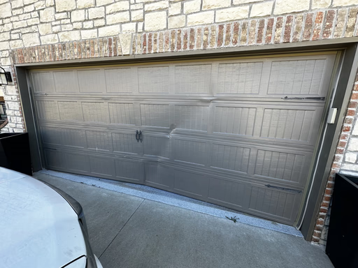 Elite Garage Door Services of Northwest ArkansasA dented residential garage door with visible damage requires professional garage door repair, highlighting the need for reliable service in Northwest Arkansas for restoring functionality and appearance.