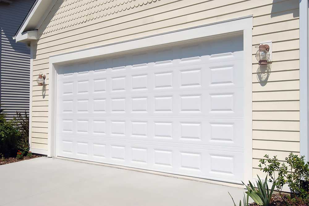 fayetteville-image Elite Garage Door Services of Northwest Arkansas-A newly installed white residential garage door in Northwest Arkansas is shown against a light yellow siding, highlighting local, reliable garage door service.