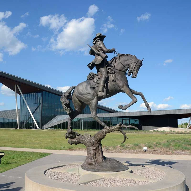 Elite Garage Door Services of Northwest Arkansas-A bronze statue of a horseback rider stands prominently in front of a modern glass building under a clear blue sky in Northwest Arkansas, capturing the essence of local heritage and culture.
