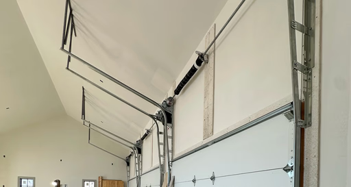 Elite Garage Door Services of Northwest ArkansasA garage interior showing overhead garage doors being installed, with visible tracks and springs, highlighting professional garage door service in Northwest Arkansas. The clean space suggests a focus on reliable and efficient installation.