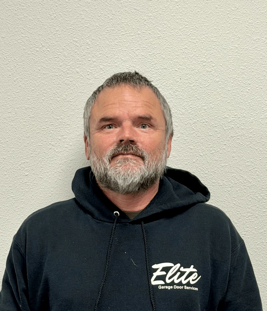 Elite Garage Door Services of Northwest ArkansasA professional technician from Elite Garage Door Services in NWA, wearing a branded hoodie, stands against a plain wall, representing reliable garage door repair and installation services in Northwest Arkansas.