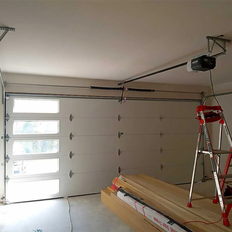 Elite Garage Door Services of Northwest Arkansas-A garage with a partially installed residential garage door, a ladder, and tools visible, indicating ongoing garage door installation in Northwest Arkansas. The scene highlights professional service with emphasis on reliable and local expertise.