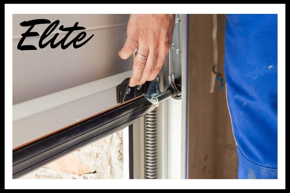 Troubleshooting Common Garage Door Opener Issues (3) Elite Garage Door Services of Northwest Arkansas-A professional technician in blue overalls adjusts a garage door spring for a reliable garage door service in Northwest Arkansas, highlighting the importance of maintenance and safety provided by Elite Garage Door.