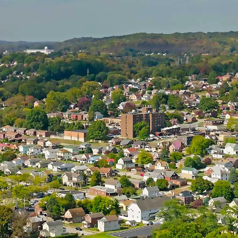 Elite Garage Door Services of Northwest Arkansas-Aerial view of a residential area with numerous houses and trees in a hilly landscape, representing a typical community in Northwest Arkansas, ideal for local garage door service needs, including garage door repair and installation.