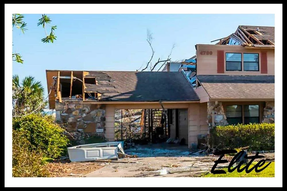 What-to-Do-When-A-Storm-Damages-Your-Garage-Door-2 Garage door with visible storm and wind damage on a Northwest Arkansas home